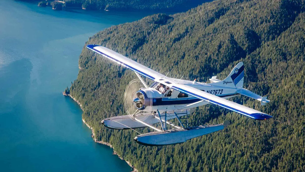 A floatplane on its floats in a Misty Fjords cove with granite walls rising behind it, on a Misty Fjords flightseeing tour from Ketchikan, Alaska