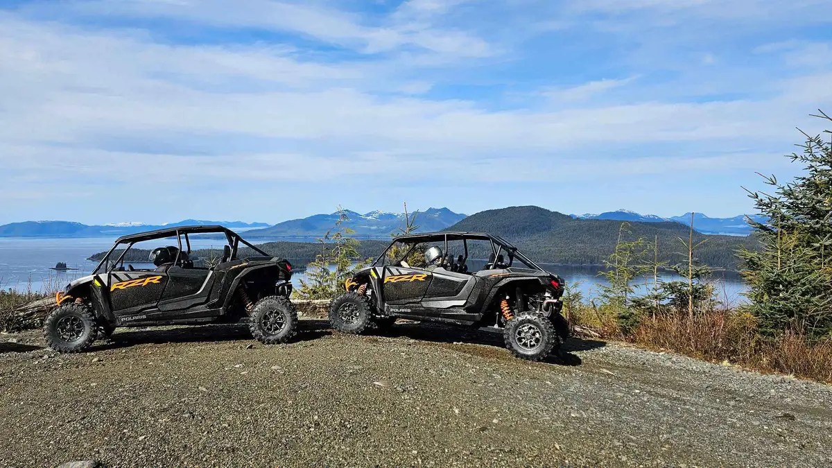 Two-seat off-road karts on a muddy logging road above the Narrows on an adventure kart expedition in Ketchikan, Alaska