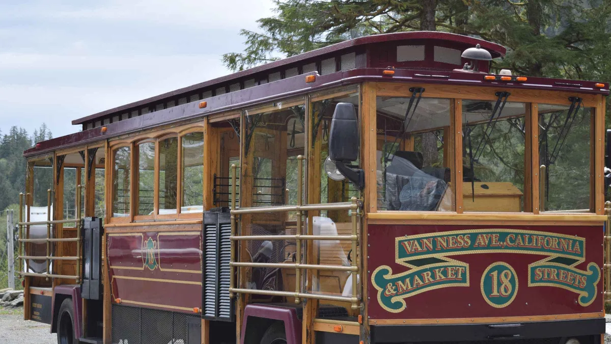A trolley parked beside the totem poles at Totem Bight on a totem pole and wildlife city tour in Ketchikan, Alaska